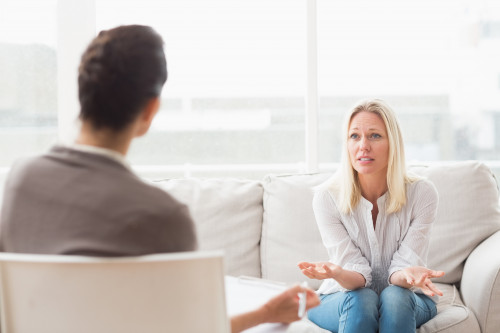 Blond woman sitting on couch during counseling session